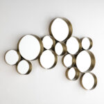 Luxe wall mirror collection featuring multiple circular mirrors in gold-tone frames arranged in an abstract pattern.