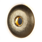 FRANCESCO Golden Bell Wall Light with circular design in gold finish and black circle emitting light from behind.