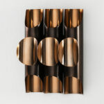 PIETRO Copper Wall Light with sculptural design featuring three cylindrical tubes and intricate perforations, ideal for sophisticated interiors.