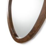 Asymmetric oval mirror with warm walnut wooden frame against white background