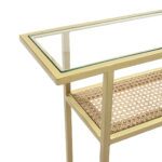 Denshaw Rattan Console Table with gold metal frame, glass top, and rattan shelf.