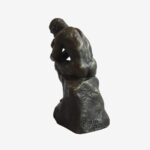 Miniature bronze sculpture of Rodin’s Thinking Man, resting on a marble base, symbolizing philosophical contemplation.