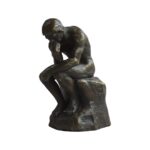 Miniature bronze sculpture of Rodin’s Thinking Man, resting on a marble base, symbolizing philosophical contemplation.