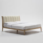 LATHORN ash wood and leather bed with curved headboard and natural wood frame, perfect for modern interiors.