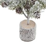 Small snowy desk Christmas tree with pinecones in a wood log base, ideal for festive decor.