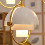 Gold and white hemisphere ceiling light with multi-level glass screen, attached to the ceiling with a chrome tube.