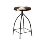 FORGE Barstool with a black metal frame and round brown and white cowhide upholstered seat, combining rustic and industrial style.