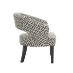 BRANT Armchair with black and beige upholstery, curved backrest, cutout opening, button detailing, and carved wooden legs.