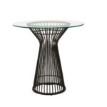 Round NIXON dining table with a clear glass top and matte black stainless steel geometric base, exuding modern retro charm.