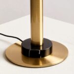 MONARCH Gold Table Lamp with a polished gold body, black marble base, glass globe, and a flying saucer-style black shade.