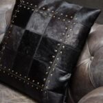 MILO Cushion with genuine suede leather, black patchwork design, and gold metallic studs, adding a luxurious touch to modern interiors.