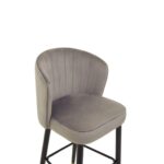 RUNE Barstool with grey velvet upholstery, cushioned seat, curved backrest, and sleek black legs with gold-tipped accents.