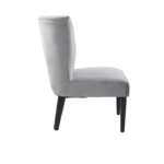 Grey velvet dining chair with a wingback design, deep-cushioned seat, black wood legs, and stud detail trim.