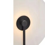 Wall light with a white marble wheel-shaped shade, matte black backplate, and metal rods, offering modern and elegant lighting.