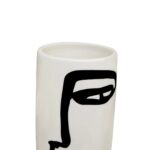 Small white ceramic vase with an abstract black face sketch, featuring a cylindrical shape and minimalist design.