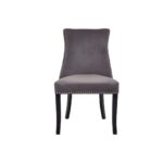 Grey velvet dining chair with button-tufted backrest, stud detailing, and solid black wood legs.