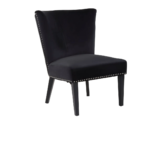 Black velvet dining chair with a wingback design, deep-cushioned seat, black wood legs, and stud detail trim.