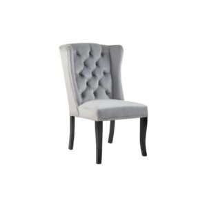 Grey velvet dining chair with a button-tufted wingback, padded seat, stud trim detailing, and curved black wood legs.