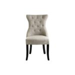 Grey linen dining chair with button tufting, black wooden legs, and a decorative metal knocker on the back.