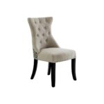 Grey linen dining chair with button tufting, black wooden legs, and a decorative metal knocker on the back.