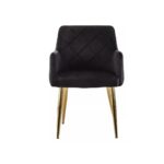 Black velvet dining chair with padded seat, quilted back, cocooning armrests, and gold splayed metal legs.