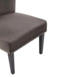 Dark mink velvet dining chair with a wingback design, deep-cushioned seat, black wood legs, and silver stud detailing.