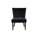 Black velvet dining chair with a wingback design, deep-cushioned seat, black wood legs, and stud detail trim.