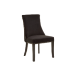 Black velvet dining chair with button-tufted backrest, warm metallic stud detailing, and dark wooden legs.