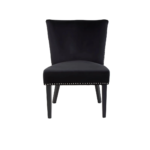 Black velvet dining chair with a wingback design, deep-cushioned seat, black wood legs, and stud detail trim.