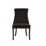 Black velvet dining chair with button-tufted backrest, warm metallic stud detailing, and dark wooden legs.