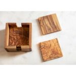 Set of four olive wood square coasters with rich grain patterns, stored in a matching acacia wood holder.