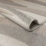 MARIE Rug – Elegant wave-patterned indoor/outdoor rug in soft greys, browns, and taupe, crafted from durable polyester.