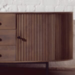 VALMONT Mango Wood Sideboard – Grey mango wood sideboard with three drawers, two doors, and black metal handles.