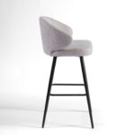Sand-coloured upholstered barstool with curved backrest and black metal legs for stylish and comfortable high seating.
