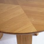 Round light oak dining table with three-panel base – Helsinki design