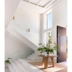 Round light oak dining table with three-panel base – Helsinki design