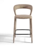 Modern taupe upholstered barstool with curved backrest and black metal footrest, ideal for kitchen islands and bar counters.