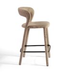 Modern taupe upholstered barstool with curved backrest and black metal footrest, ideal for kitchen islands and bar counters.