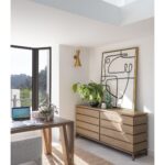 Eight-drawer oak chest with minimalist design and antique gold metal legs, made from FSC-certified natural wood for contemporary interiors.
