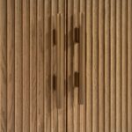 Natural oak sideboard with slatted wood doors, gold metal base, and modern storage design.