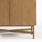 Tall oak cabinet with slatted wooden doors, gold metal base and handles, modern storage solution in natural finish.