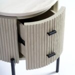 Round greyish-white oak side table with white stone top, black metal legs, and a storage drawer—modern and minimal bedside table design.