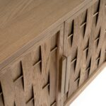 Natural oak wood sideboard with four sculpted relief doors and aged gold metal legs, offering elegant storage for living or dining spaces.