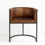 Brown leather armchair with black metal legs, featuring a vintage-modern design perfect for dining or lounge settings.