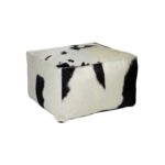 Black and white TAURUS cowhide pouf with natural pattern, ideal for modern and rustic interiors.