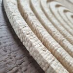 JULIE circular wall art with natural and dark brown woven palm in oak veneer frame by Versmissen.