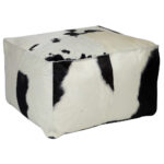 Black and white TAURUS cowhide pouf with natural pattern, ideal for modern and rustic interiors.