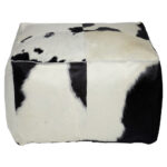 Black and white TAURUS cowhide pouf with natural pattern, ideal for modern and rustic interiors.