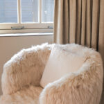 CARBANA Off-White New Zealand Sheepskin Armchair – A curved beige armchair upholstered in ultra-soft, hand-selected New Zealand sheepskin.