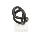 Matte black twisted knot sculpture on a raw-edged white marble base.